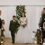 Little brother walks a bride down the aisle through rows of audience