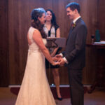 Bride and groom smiling at each other in front of an officiant